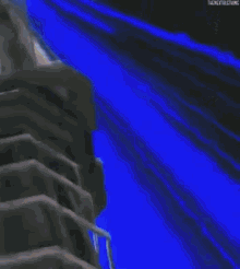 a person is standing in a dark room with a blue light coming out of the ceiling .