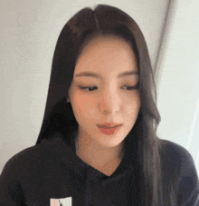 a close up of a woman wearing a black hoodie