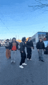 a group of young men are dancing in the street .
