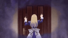 a woman is standing in front of a door with her hands on it .