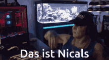 a man wearing headphones stands in front of a computer with the words das ist nicals on the screen