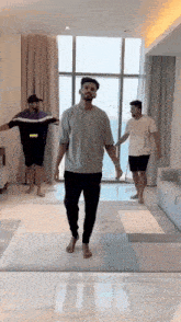 a group of men are standing in a living room holding hands