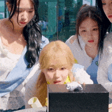 a group of young women are looking at a box that says ' a ' on it