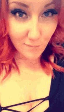 a woman with red hair is wearing a black top