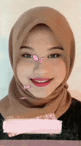 a close up of a woman wearing a hijab with stickers on her face .