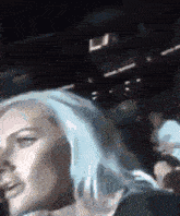 a blurry picture of a woman with blue hair in a dark room
