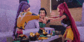 three cartoon girls are standing around a table with food