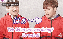 two young men in red jackets are standing next to each other and one of them is asking the other what he is doing .