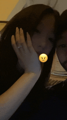a woman with a ring on her finger holds her hand to her face with an angry face on it