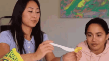 two women are holding a bag of reeses candy
