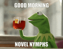 kermit the frog is holding a glass of tea with a label that says lipton