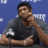 a man is sitting in front of a microphone that says nba app