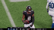 a football player with the number 8 on his jersey stands on the field