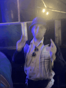 a man wearing a hat and a jacket giving the middle finger