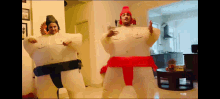 a man and a woman are dressed up as sumo wrestlers