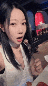 a woman is eating a piece of pizza with a fork in her hand