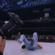 a wrestler is kicking another wrestler in the head during a match .