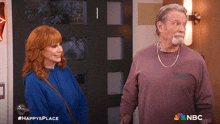a man and a woman are standing next to each other in front of a door with the nbc logo on the bottom right