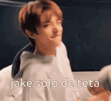 a young man is making a funny face with the words " jake solo de teta " written below him .