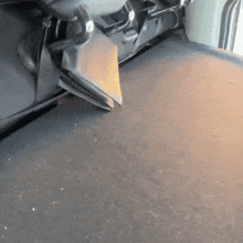 a dirty floor in a car with a few pieces of carpet