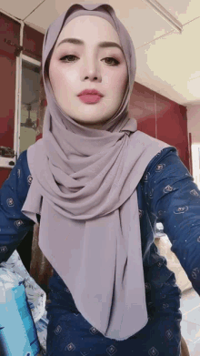 a woman wearing a hijab and a blue shirt
