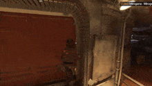 a man in a video game is running towards a door that says open on it