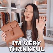 a woman holding a brown purse with the words i 'm very thankful above her
