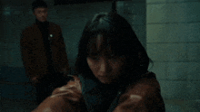 a woman is pointing a gun at a man in a dark room .