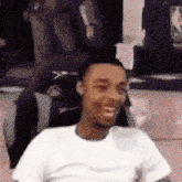 a man in a white shirt is smiling in front of a mirror