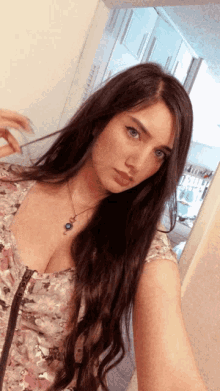 a woman taking a selfie with a necklace on her neck