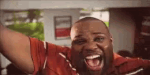 a man is screaming with his mouth open and his arms in the air .
