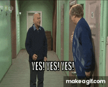 two men standing in a hallway with the words yes yes yes on the screen