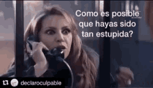 a woman is talking on a phone with a caption that says `` como es posible que hayas sido tan stupida ? ''