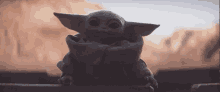 a baby yoda from star wars is sitting on a ledge