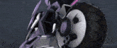 a close up of a purple and white motorcycle with a large wheel .