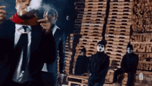 a man in a suit and tie is smoking a cigarette