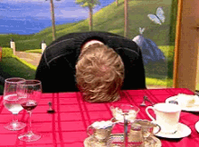 a man sitting at a table with his head on the table