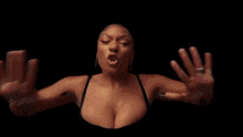 a close up of a woman 's face with her hands outstretched in a dark room .