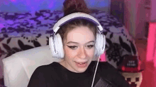 a woman wearing headphones is sitting in a chair and making a funny face .