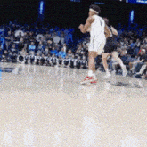 a basketball player with the number 1 on his jersey runs on the court