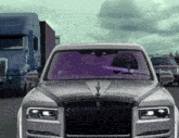 a rolls royce car is driving down the road