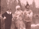 a black and white photo of three men standing next to each other with the website gifrun.com in the corner