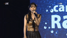 a woman singing into a microphone in front of a sign that says " live "