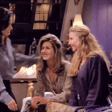 three women are sitting in a room with a purple curtain