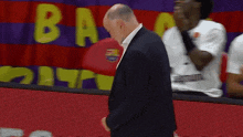 a man in a suit stands in front of a banner that says ba
