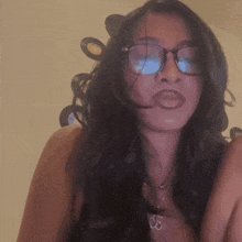 a woman wearing glasses and a necklace with the letters ss on it