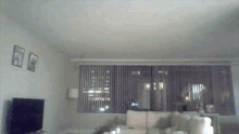 a living room with a couch a television and a window