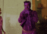 a man with purple paint on his face stands next to a woman in a pink dress