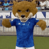 a mascot wearing a blue adidas shirt is dancing on a field
