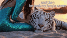 a woman in a mermaid costume is petting a white tiger